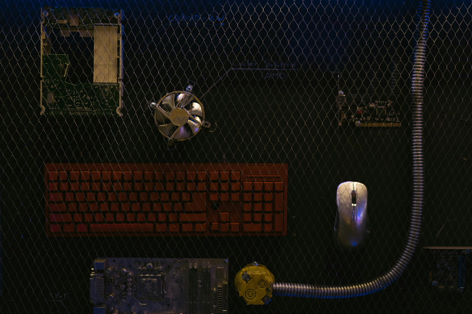 Top-down view of a computer setup with keyboard, mouse, and various electronic components on a dark surface. TokenPi Store